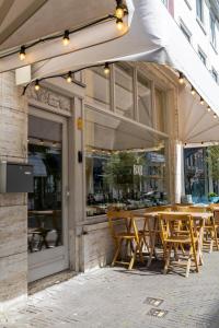 a group of tables and chairs outside of a store at EL HOTEL - The Hague in The Hague +20 photos