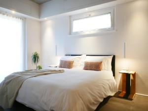 a bedroom with a large white bed with a window at Restorative stay Garden Jacuzzi Lake View in Lierna