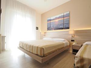 a bedroom with a bed and a large window at Hotel Angelo in Caorle