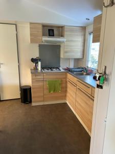 a kitchen with wooden cabinets and a stove top oven at Mobil-home Messanges in Messanges