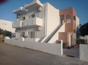 a white building with stairs on the side of it at IASONAS APARTMENTS in Mastihari