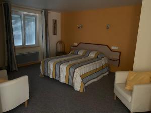 a bedroom with a bed and a chair and a window at Les chambres de Fred in Gorses