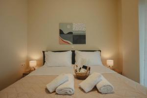 a bed with two towels and a basket on it at Almy Sea Apartment in Karistos