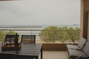 a balcony with a table and chairs and a view of the ocean at Almy Sea Apartment in Karistos