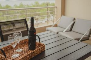 a bottle of wine sitting on a table with two glasses at Almy Sea Apartment in Karistos
