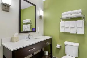 a bathroom with a sink and a toilet and a mirror at Sleep Inn & Suites Liberty in Liberty +10 photos