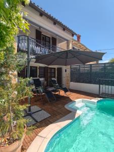 a house with an umbrella and a swimming pool at Villa Ester in Rovinj
