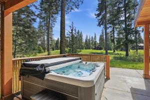 a hot tub on the back porch of a house at Serenity on 13 Suncadia-luxury 4bd ensuite spa retreat with Sauna, Steam Shower, Jacuzzi, Hot tub, Fire Pit & on-site EV chg in Cle Elum