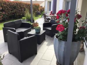 a patio with chairs and a vase with red roses at Rose in Tonnay-Charente +4 photos
