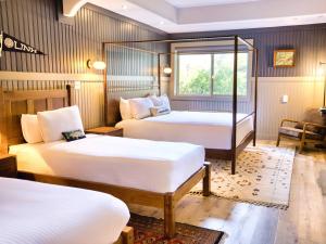 a hotel room with two beds and a window at Hideaway Inn Mt Sunapee in Newbury +40 photos