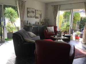 a living room with a couch and chairs and sliding glass doors at Rose in Tonnay-Charente