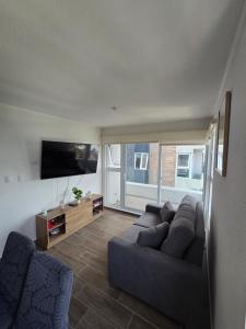 a living room with a couch and a flat screen tv at Apartamento La Villa del Castillo in El Rodeo