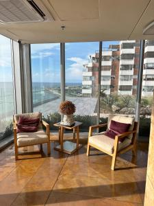 two chairs and a table in front of a large window at H2 Hyatt Vista Mar!! in Cartagena de Indias