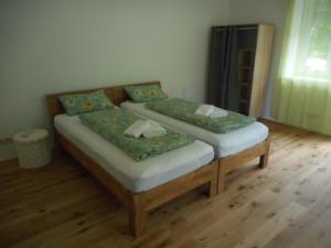 two twin beds in a room with wooden floors at Eight in Obertraun