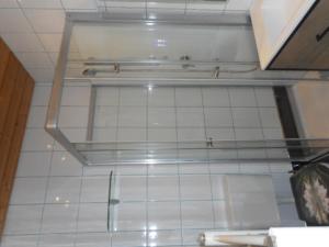 a room with a white tiled wall and a shelf at Eight in Obertraun