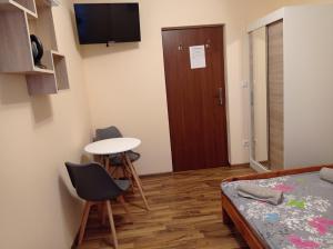 a small room with a bed and a table and chairs at POLANA in Leśna