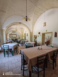 a restaurant with tables and chairs in a room at Masseria Don Egidio in Melendugno