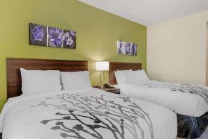 two beds in a hotel room with green walls at Sleep Inn & Suites Liberty in Liberty