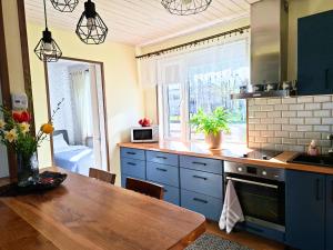 a kitchen with blue cabinets and a table and a window at Meie Hiiumaa majutus Kärdlas in Kärdla