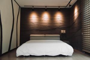 a bedroom with a white bed and a wall with lights at Byeoldeul-ui Gichim Pension in Inje +37 photos