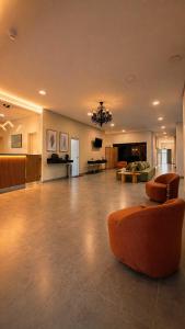 a large living room with an orange chair and a couch at Smart Hotel GRU in Guarulhos