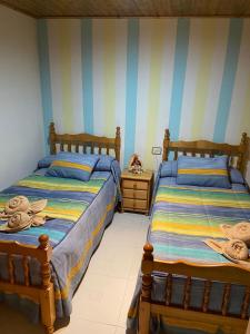 two beds in a room with striped walls at Apartamento Berro in Guadalaviar