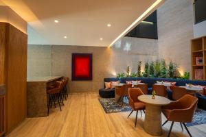 a restaurant with a bar and tables and chairs at Ambulan Mexico City in Mexico City