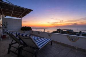 a chair sitting on a balcony with a sunset at Villa Raf in Vico Equense