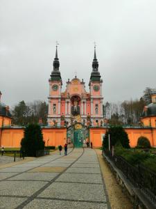 a large pink building with a clock tower at Apartament Mazury in Kętrzyn