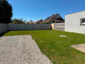 a backyard with a fence and a grass yard at Maison 2 chambres avec jardin et parking privatif in Saran