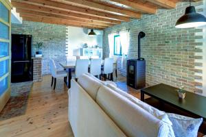 a living room with a couch and a table and a brick wall at Villa Stone Pearl with heated swimming pool in Sveti Filip i Jakov