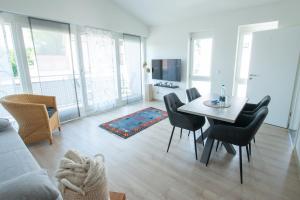 a living room with a dining room table and chairs at Am Bienenfeld in Ettenheim
