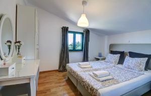 a bedroom with a bed with a desk and a mirror at Villa Stone Pearl with heated swimming pool in Sveti Filip i Jakov +53 photos