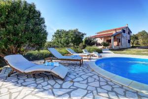 a patio with lounge chairs and a swimming pool at Villa Stone Pearl with heated swimming pool in Sveti Filip i Jakov