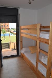 a bedroom with bunk beds and a view of a pool at Apartament Lo Passador in Deltebre