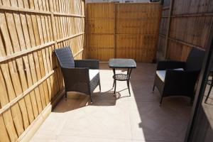 a patio with chairs and a table and a fence at Harrow Boutique Suites in Harrow