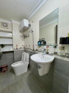 a bathroom with a sink and a toilet and a mirror at Hava House Lang Son in Lạng Sơn