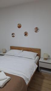 a bedroom with a white bed with two lights on the wall at SaGa Apartament in Topliţa