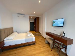 a bedroom with a bed and a desk and a television at Villa Scorpio in Qeparo