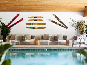 a pool with chairs and surfboards on the wall at Hideaway Inn Mt Sunapee in Newbury