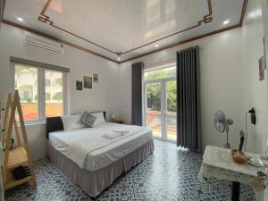 a bedroom with a bed and a large window at Tam Coc Harmony Homestay in Vũ Lâm +72 photos