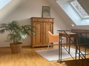 an attic room with a desk and a potted plant at Gemütliche Ferienwohnung zwischen Europa-Park und Schwarzwald in Lahr