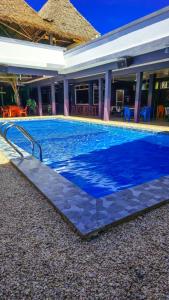 a large swimming pool with blue water in front of a house at 7G Residency Bwejuu in Bwejuu