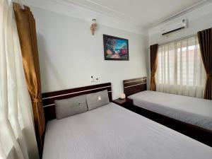 a bedroom with two beds and a window at Hava House Lang Son in Lạng Sơn
