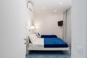 a white bedroom with a bed with a blue blanket at Relais Villa Ettore in Barano d'Ischia +61 photos