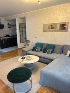 a living room with a blue couch and a table at Belgrade Apartment 3 in Zvezdara