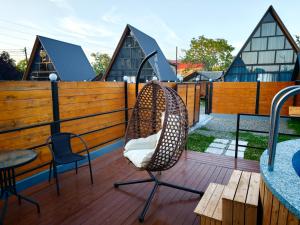 a wooden deck with two chairs and a table at Golden Coast in Batumi