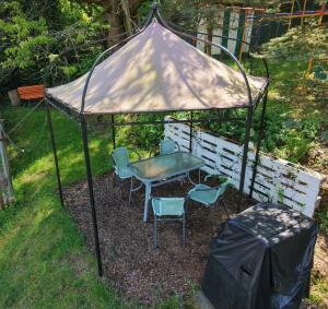 a gazebo with a table and chairs in a yard at Ferienwohnung am Wald in Sebnitz