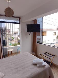 a bedroom with a bed and a flat screen tv at VIVEMAR PUNTA HERMOSA - Beach House Lima - Perú in Punta Hermosa