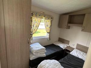 a small room with two beds and a window at Glenan01 in Clohars-Carnoët +6 photos